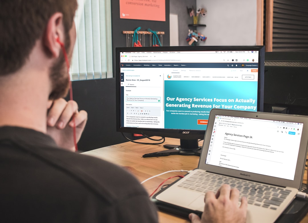 Web designer analyzing a landing page on dual monitors, reviewing conversion optimization strategy. Photo by Unsplash.