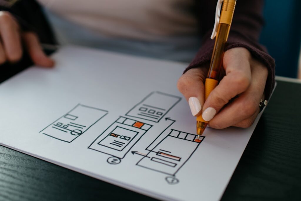 UX designer sketching mobile-first single-column wireframe layout for a landing page