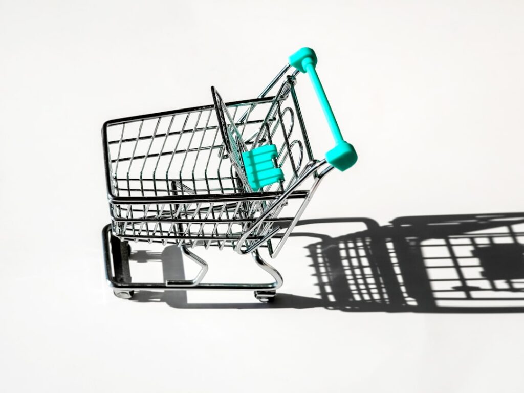Empty miniature shopping cart on a white background representing ecommerce cart optimization